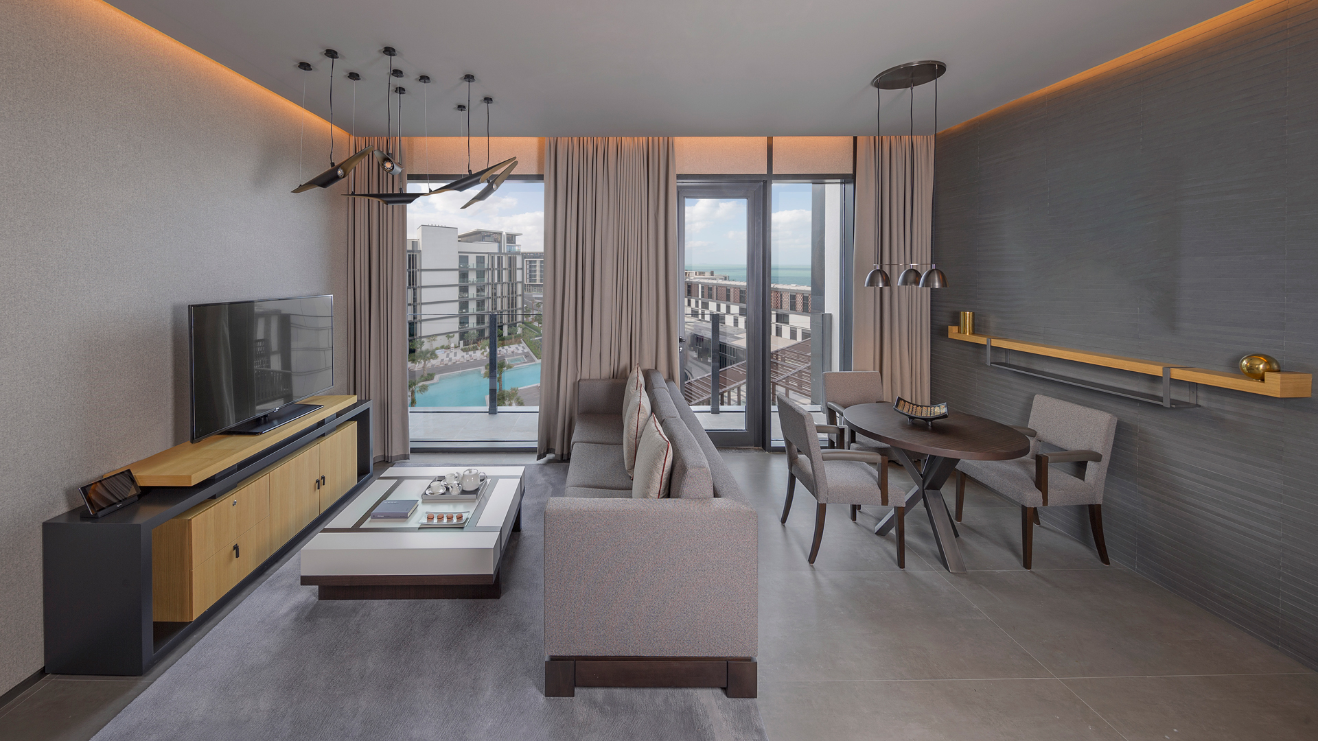 Luxurious sitting area with modern decor overlooking a pool at one bedroom Banyan Tree Dubai residence.